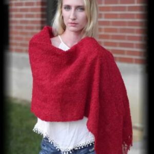 Stylish red shawl on woman by brick wall