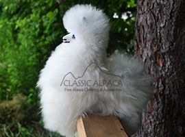 Fluffy alpaca toy on wooden surface