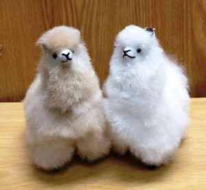 Fluffy toy llamas on wooden surface
