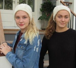 Two women wearing knit headbands on porch