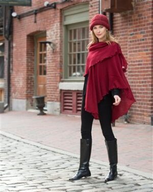 Woman in red poncho on cobblestone street