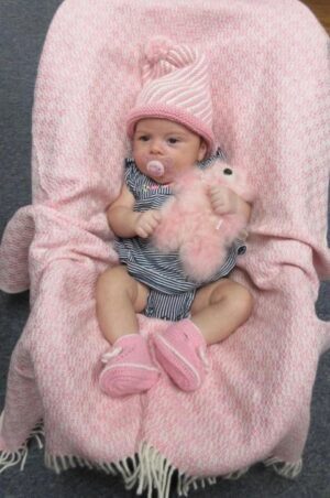 Infant holding pink stuffed toy