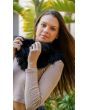 Model holding black fur scarf outdoors