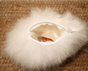 Open white zippered furry pouch