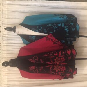 Two elegant jackets with floral patterns hanging on a decorative wall hook.