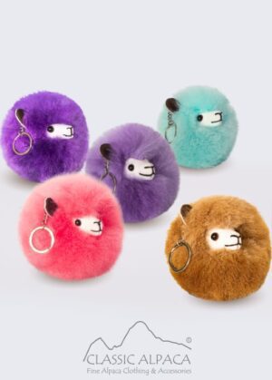 Colorful fluffy keychain plushies with various facial expressions.