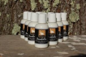Bottles of vanilla scented product on a rustic wooden surface.