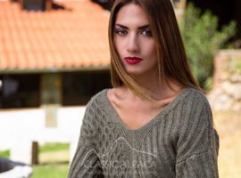 Young woman with long hair in a knitted sweater outdoors.