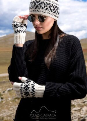 Woman in black sweater and patterned gloves poses outdoors.