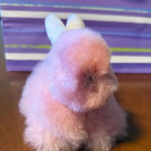 A fluffy pink bunny-shaped plush toy with white ears.