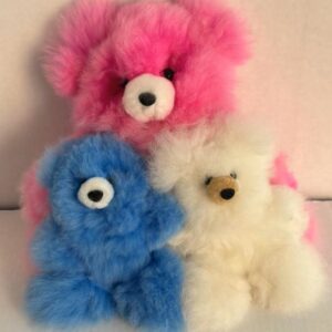 Three colorful fluffy teddy bears stacked together against a plain background.